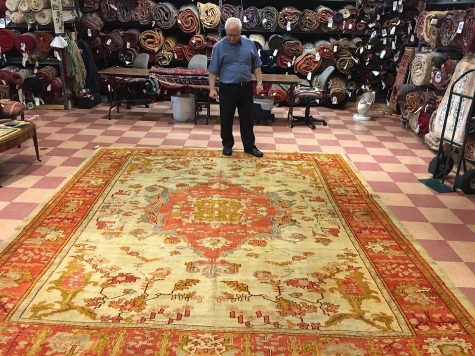 Ali Taghavi looking at rug