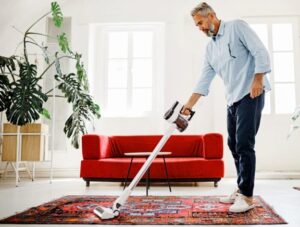 Man is Cleaning Rug During Fall Season